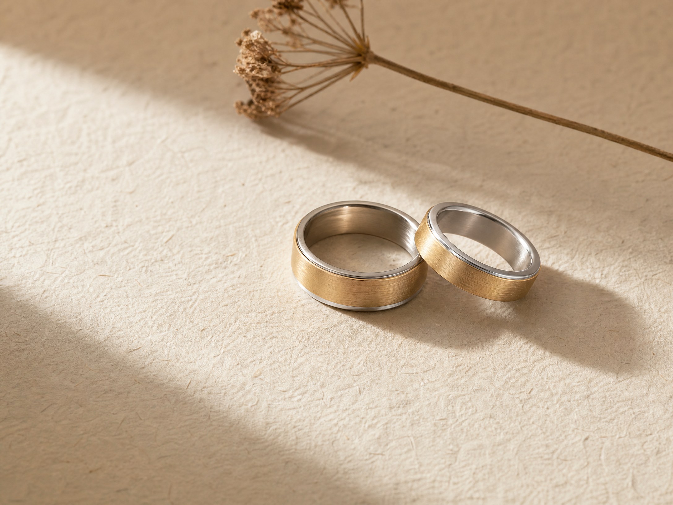 Close detail of two wedding bands on handmade paper